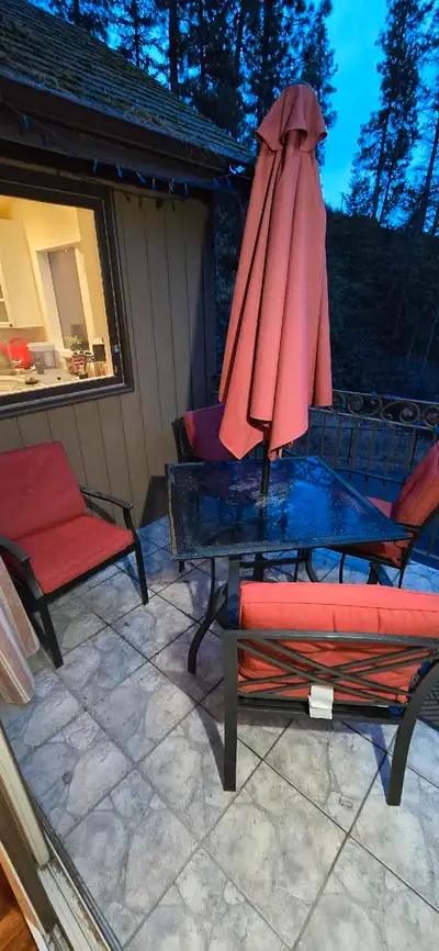 Patio table set with four chairs all cushions in good condition and the umbrellas in Perfect conditi...