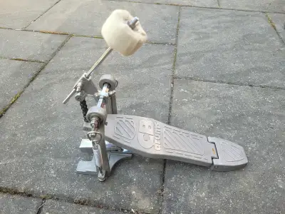 Durable CB Drums bass drum pedal has a single chain drive mechanism. Has dual adjustable tension spr...
