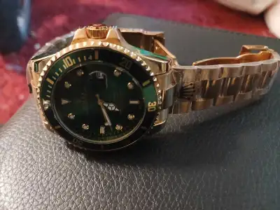 This Rolex Submariner features a striking green dial and gold-tone finish, offering a bold statement...