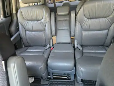 This reliable silver Honda Odyssey features a spacious interior with grey leather seating, perfect f...