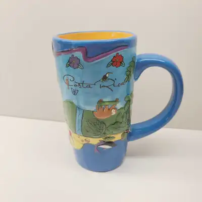 This is a Costa Rica mug, perfect for coffee or tea. It features a vibrant design with sloths, touca...