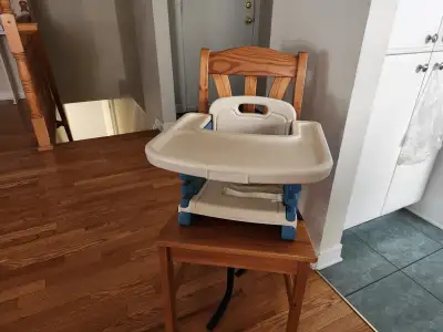 Child booster seat includes a removable tray. Straps to a chair and converts it to a high char or ca...