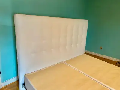 This stylish, used king-size white leather headboard adds a touch of modern elegance to any bedroom....
