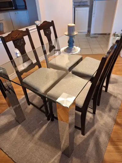 Glass Diningroom table 55 inches x32 inches ,with 4 wooden chairs which were newly upholstered last...