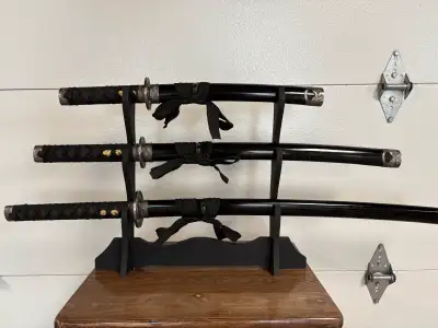 I'm offering a used decorative katana sword set that includes three swords of varying sizes, each wi...