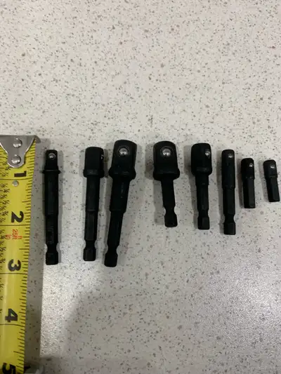 This is a set of 8 black socket adapter extensions. They appear to be made of metal and come in vari...