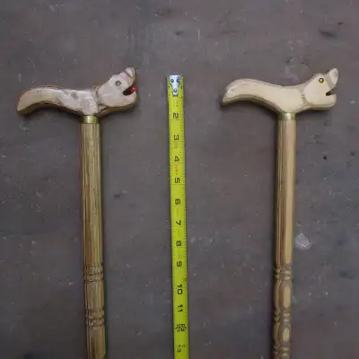 Wooden canes with either fish or animal styled handles, I can't quite tell exactly what they are. Th...