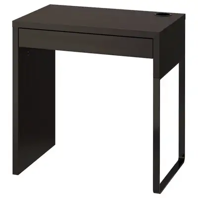 Compact IKEA MICKE desk has a black-brown wood effect finish. It has a single wide drawer for storag...
