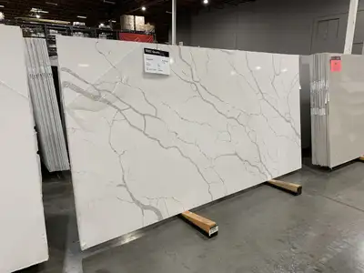 This premium Calacatta quartz slab features a stunning white base with elegant, bold grey veining, p...