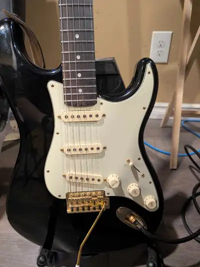 Specifications: * Body: Black * Pickguard: Cream * Hardware: Gold * Neck: Maple * Fingerboard: Rosew...