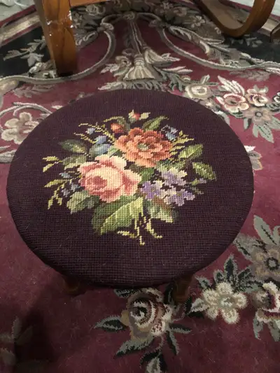 This round footstool features a needlepoint floral design and sturdy wooden legs. It's a delightful...