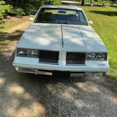1985 OLDS-CUTHS- BROM WHITE WITH REn HALF ROOF DELUXE INTREOR 305 4 BBL DUAL EXARUST AIR COND. POWER...