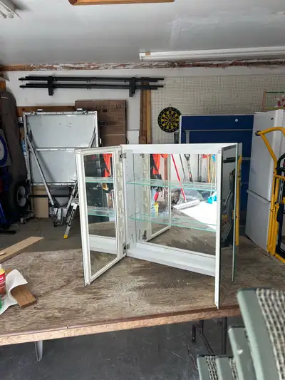 This is a mirrored medicine cabinet, perfect for a bathroom or any space needing extra storage with...
