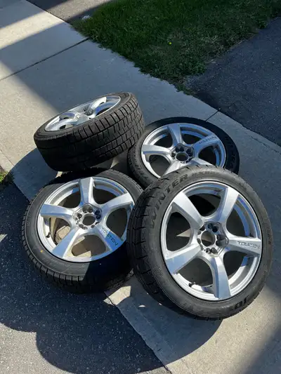 These pre-owned Touren 18-inch wheels are paired with 245/45R18 winter tires, offering reliable grip...