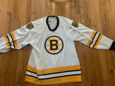 2 Boston Bruins Jerseys. The white one is a girls large. Has a 4 small material pulls on it . The bl...