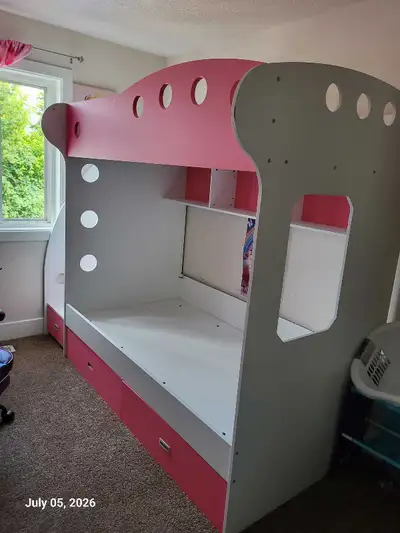 This pre-loved Jysk pink and white single bunk bed features a playful design with built-in storage d...