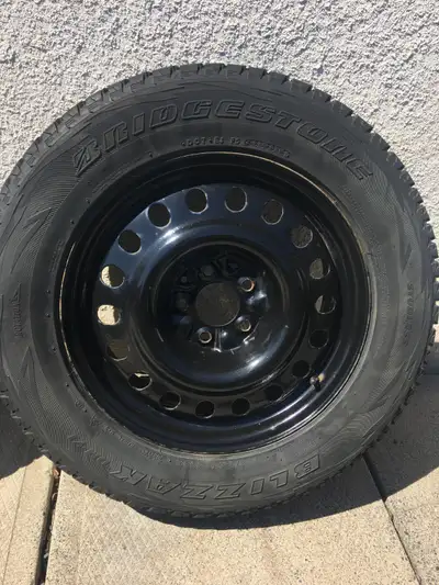 A set of four used blizzak winter tires 255/65R17 size with lug nuts . Black steel rims with bolt pa...