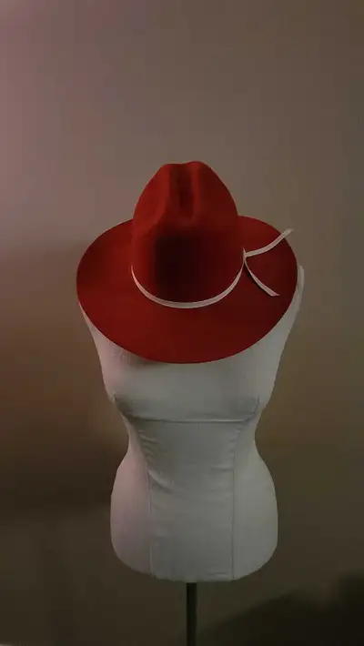 Elevate your ensemble with this striking red cowboy hat featuring a crisp white ribbon band, offered...