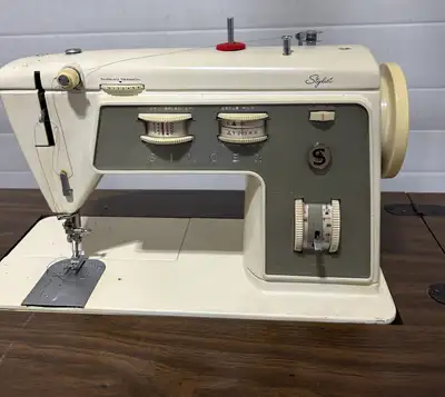Vintage Singer sewing machine from 1975. It comes with a stylish mid-century cabinet with flip out p...
