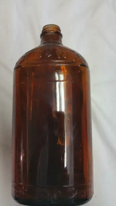 UP FOR SALE WE HAVE THIS VINTAGE BROWN GLASS BOTTLE The letters are raised Embossed at the neck, sho...