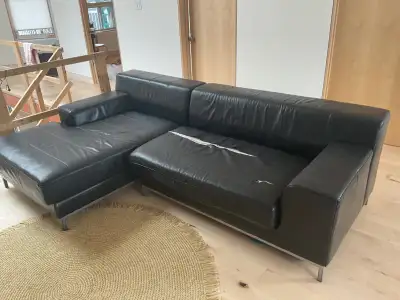 Canapé sectionnel Ikea Kramfors en cuir noir. Une partie en bon état, sur l'autre partie un coussin...