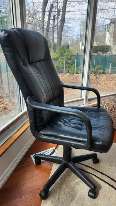 This black office chair is designed for comfort and functionality, featuring a rolling base and adju...