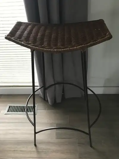 Brown wicker saddle-seat stool with dark brown metal base, View more
