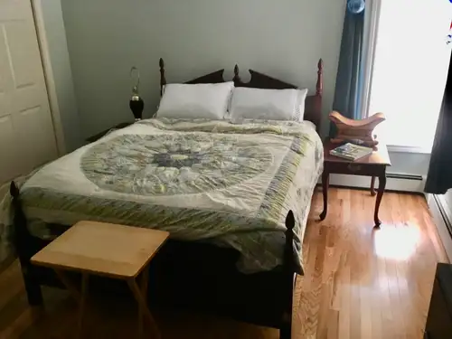 A large furnished room with a large double closet for storage, television, and a bar refrigerator. Y...