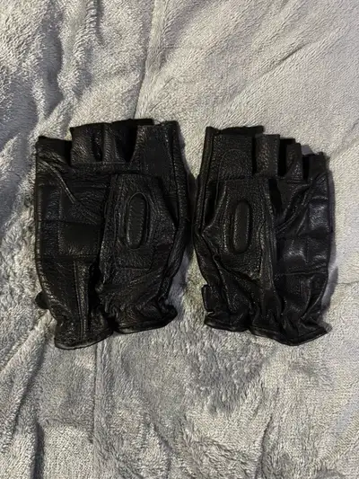 These are a pair of used black leather fingerless motorcycle gloves, perfect for any rider looking f...