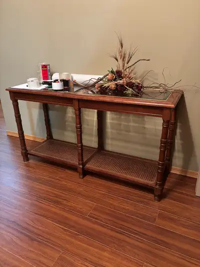 Add a touch of elegance to your living space with this used but well-maintained wood and glass sofa...