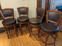 Four wood and leather swivel bar stools