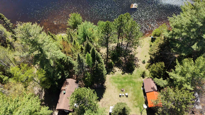 Fully insulated and furnished two-room cottage on a wooded lot with 135 feet of waterfront on Lac Te...