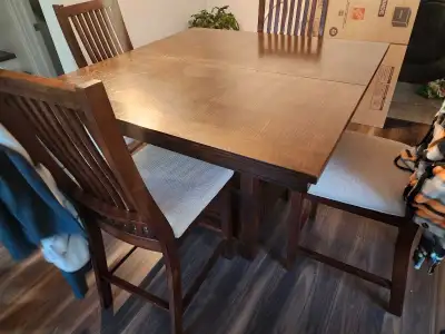 Pub style. Has collapsible leaf. Storage built into base. Includes 9 chairs. Paid $3800