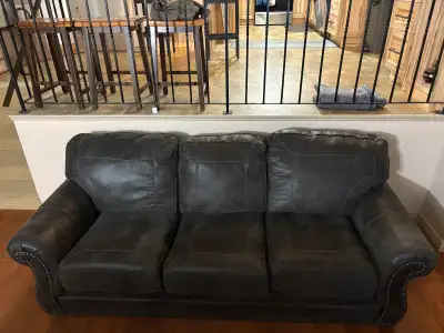 Beautiful dark brown (charcoal tone) faux-leather 3-seat sofa from Ashley Furniture. About 4 years o...
