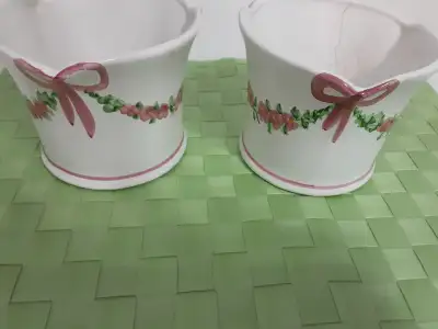 Two white with pink and green ceramic flower pots for sale. Can use for real plants/flowers such as...