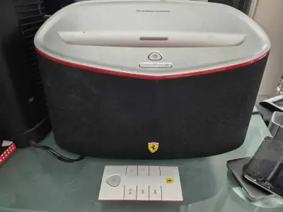 Listen to your music with this pre-owned, but well-maintained, black Scuderia Ferrari bluetooth spea...
