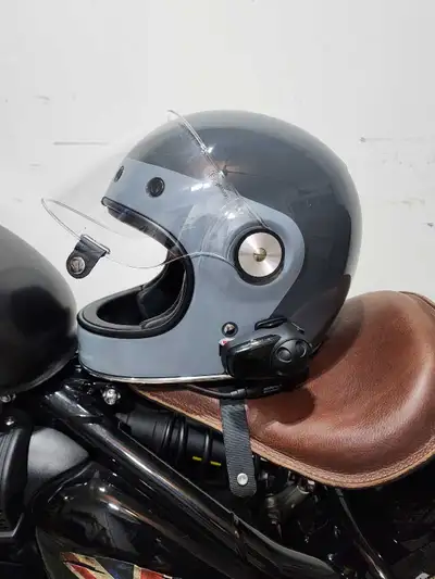 This is a Bell motorcycle helmet in excellent condition, featuring a sleek grey finish and a clear v...