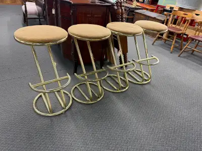 Vintage mid century brass finish bar stools. They have wear mostly on the foot rest (some brass fini...