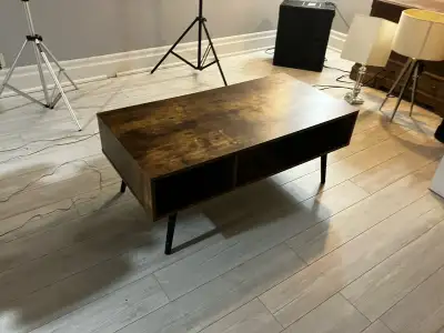 This coffee table features a rustic brown finish, adding a touch of warmth to any living room, den,...