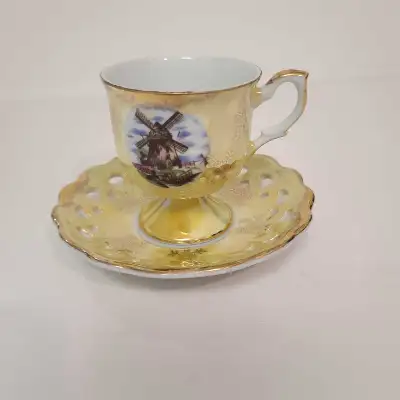 Versatile tea cup and saucer with windmill image and gold plated.