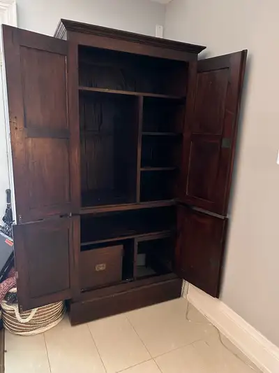 Teak wooden armoire/cabinet offers ample storage, perfect for any bedroom or living space. It's in g...