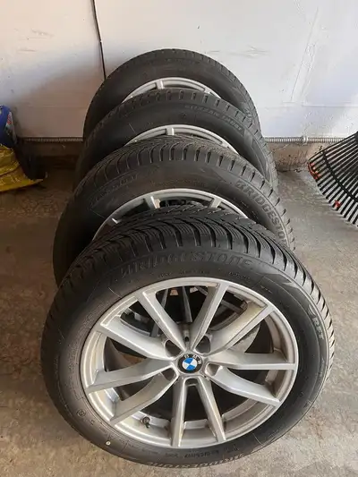 For sale is a set of used BMW rims and tires featuring Bridgestone Blizzak tires, perfect for winter...