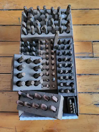 Assorted machinist tools: number and letter metal stamps, 4 micrometers, calipers, tool box, machini...