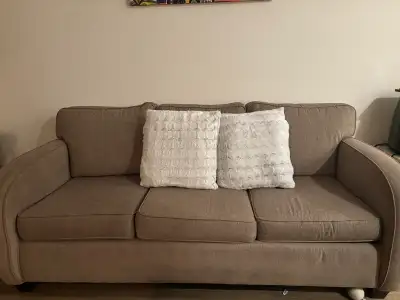 This cozy, used three-seater couch features a durable fabric and comfortable cushions, perfect for a...