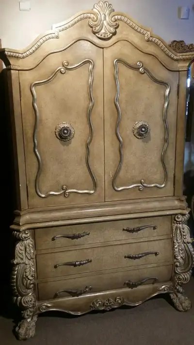 This is a designer Armoire with a proprietary multilevel finish with antiqued cream dusting. It has...