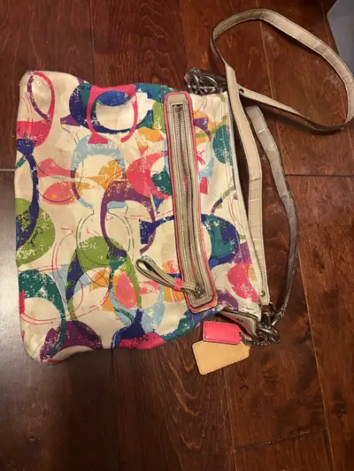 Check out this super cute Coach crossbody bag! It's got a fun, colourful pattern and a convenient zi...