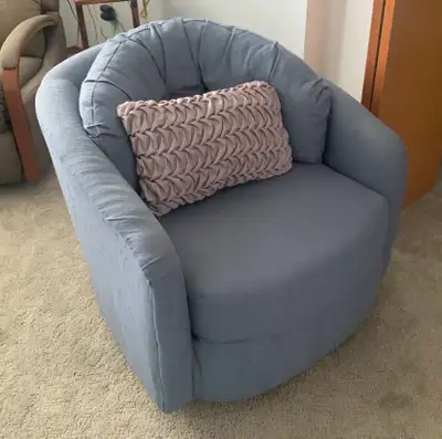 Upholstered swivel barrel TUB CHAIR in a light/medium blue-grey textured fabric. Rounded back with a...