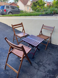 Table et trois chaises pliant en bois très propre.