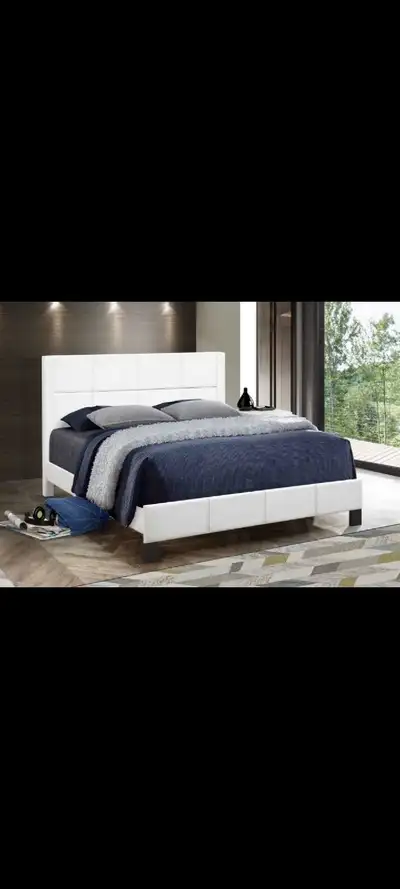 This modern queen bed features a sleek, white faux leather finish, making it a stylish addition to a...