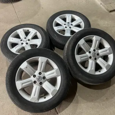 Set of four 235/60R18 Bridgestone all season tires mounted on aftermarket aluminum alloy rims used o...